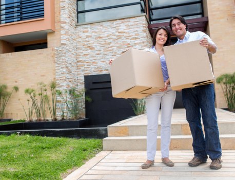 Professional movers loading household items into a van